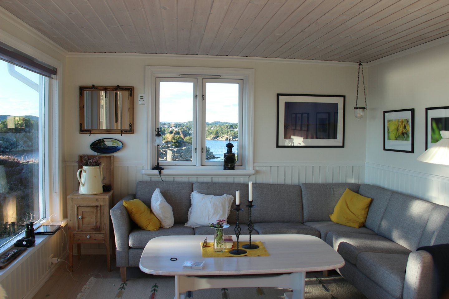 Living room with L-shaped sofa and ocean view.
