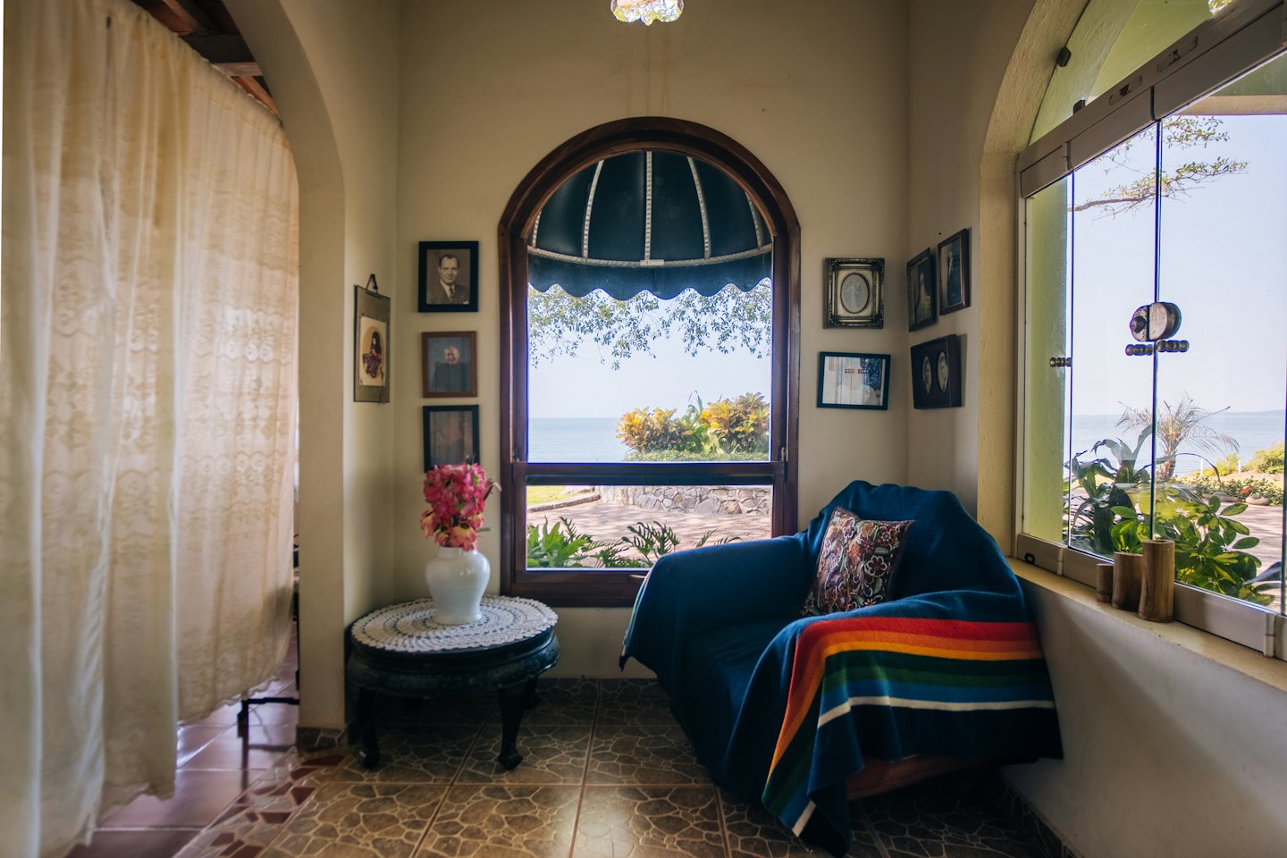 Cozy reading nook with armchair and ocean view.